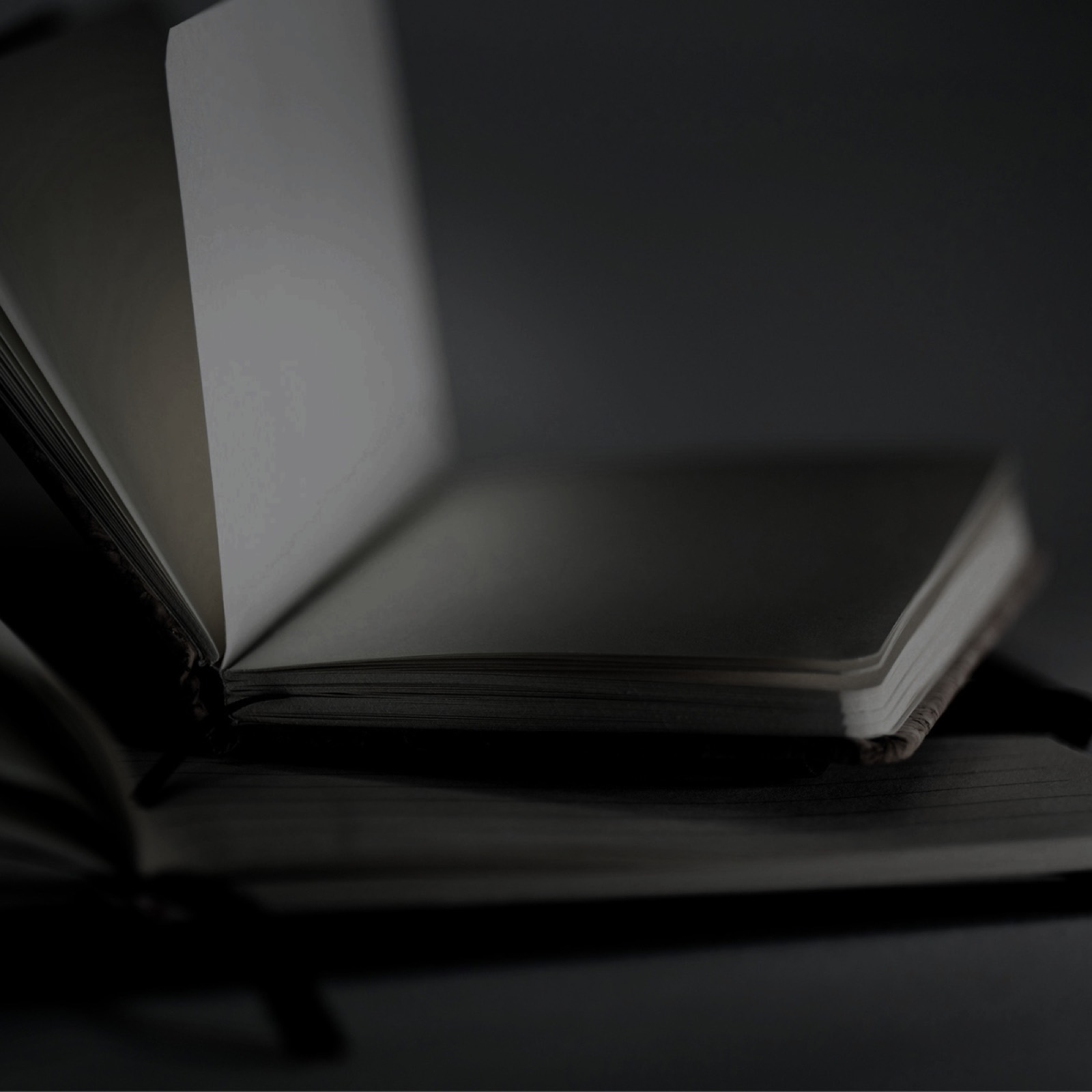 An open notebook in low light, black and white